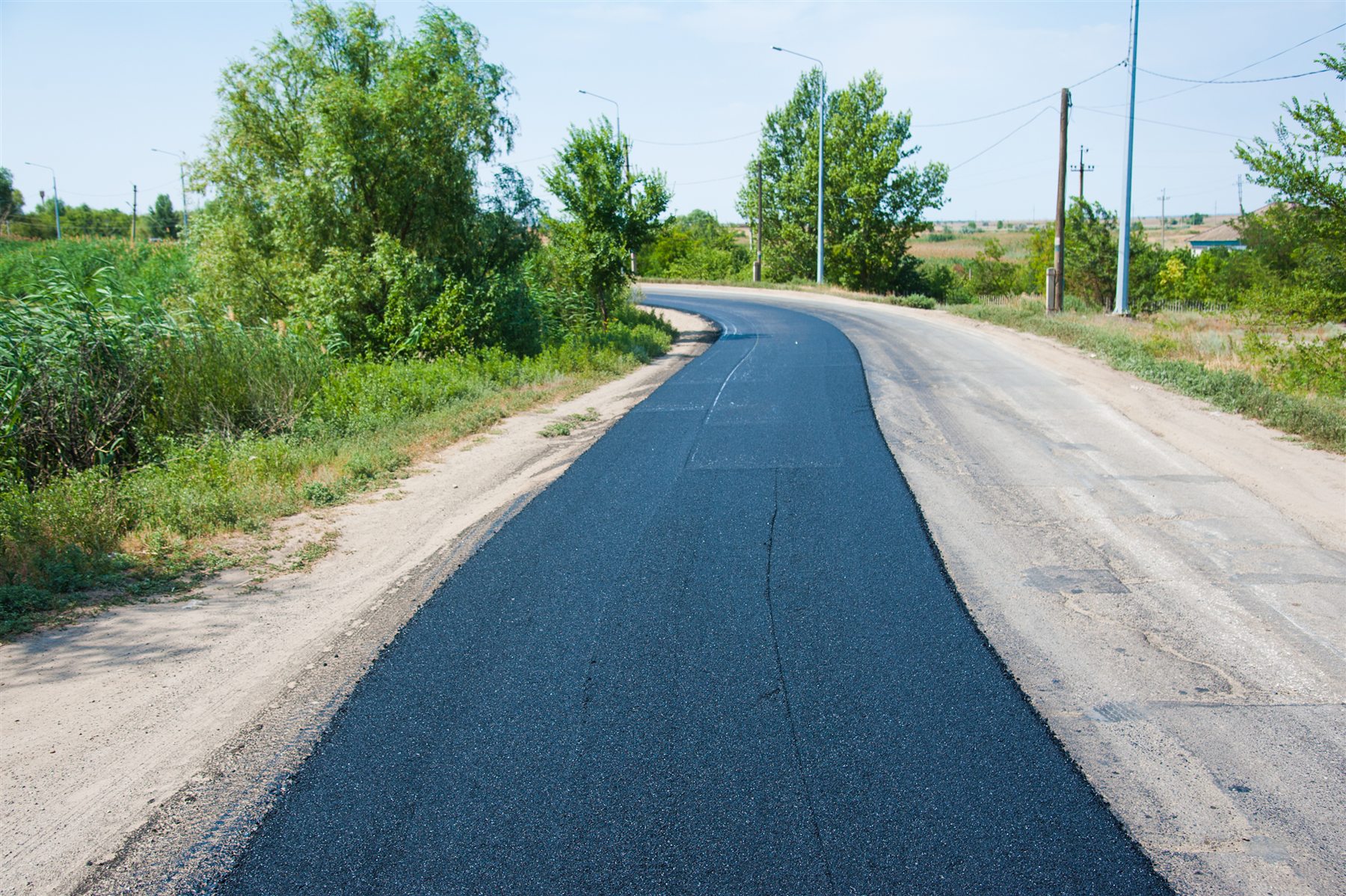 Fresh asphalt lane beside an older road surface