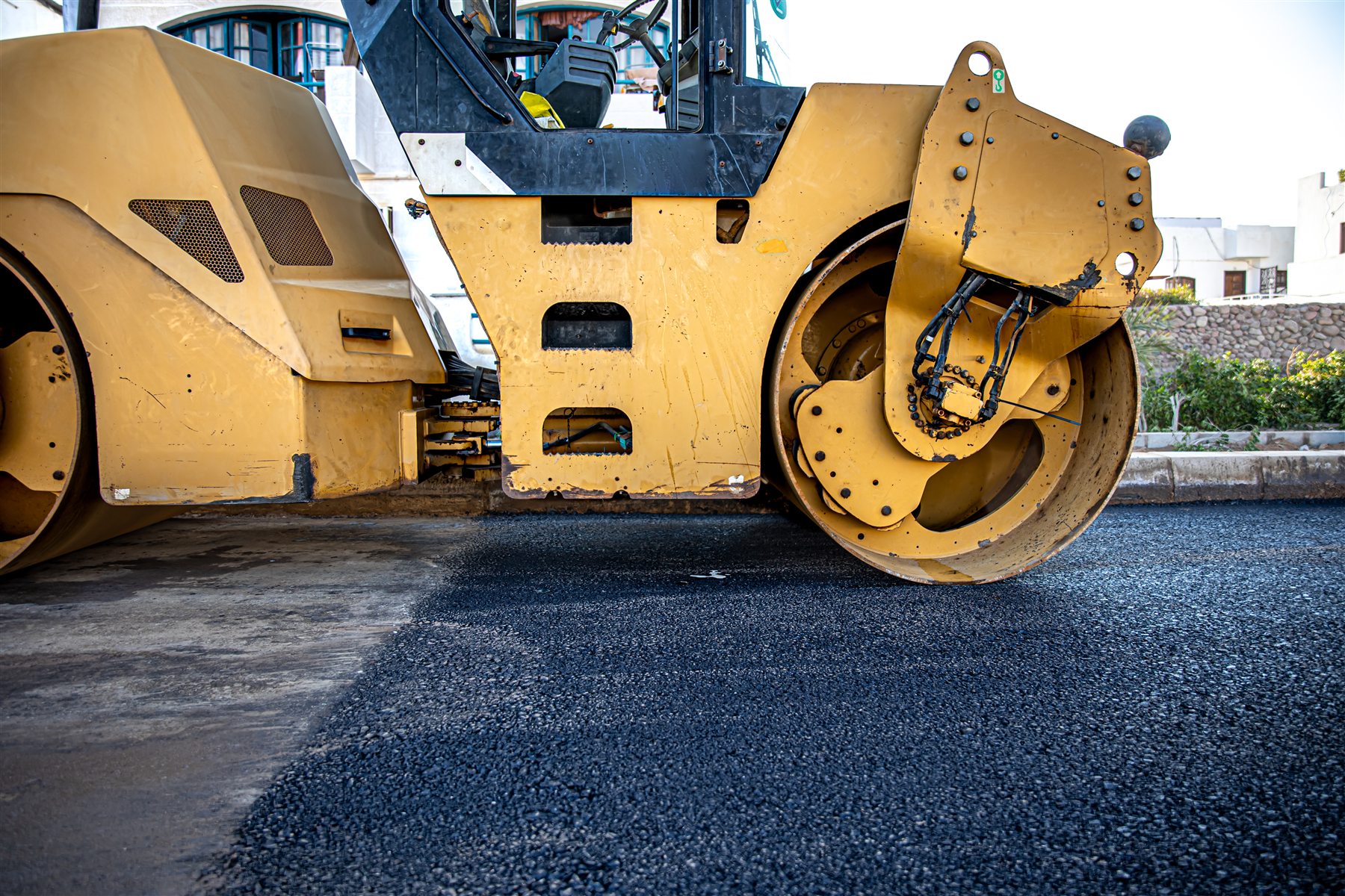 Road roller compacting a newly paved asphalt surface